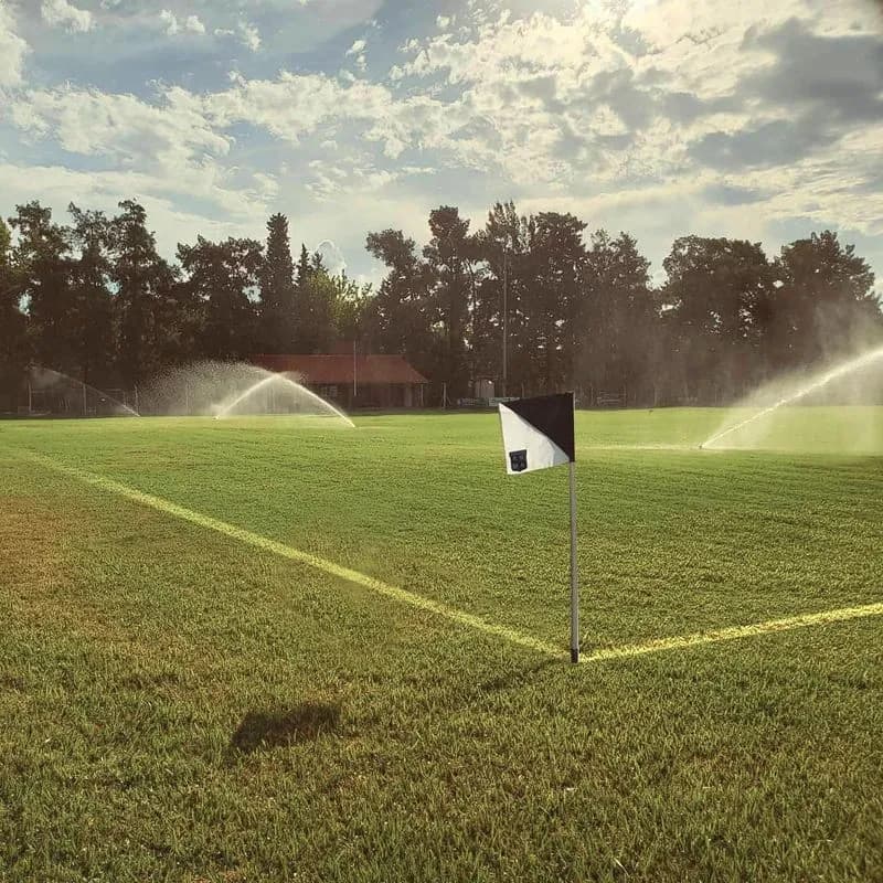 Corner de la cancha de Roma con el riego puesto.